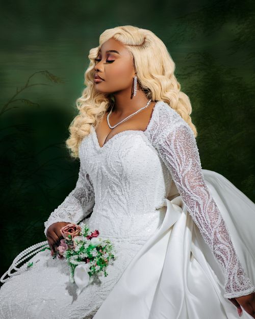 Free A beautiful bride in an elegant white dress holding a bouquet, exuding grace and poise. Stock Photo