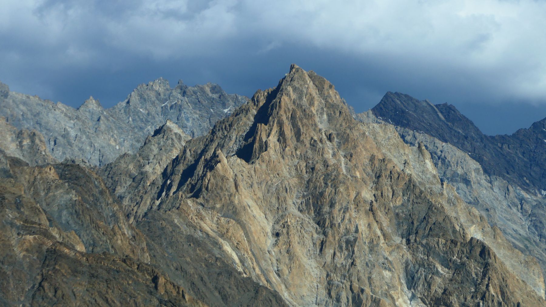 Stunning mountain peaks of Gilgit-Baltistan under a dramatic sky, epitomizing natural beauty.