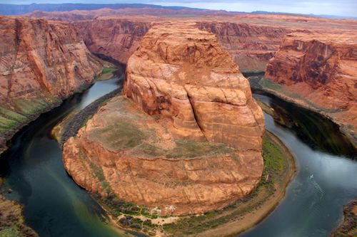 Free Breathtaking aerial view of Horseshoe Bend's iconic red rock formations and meandering Colorado River. Stock Photo