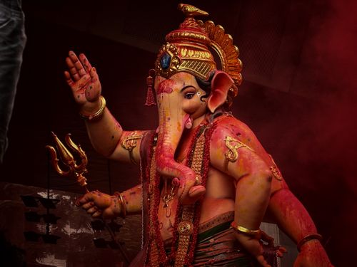 Free Close-up of a colorful Ganesh statue adorned with ornaments and red hues during a festival celebration. Stock Photo