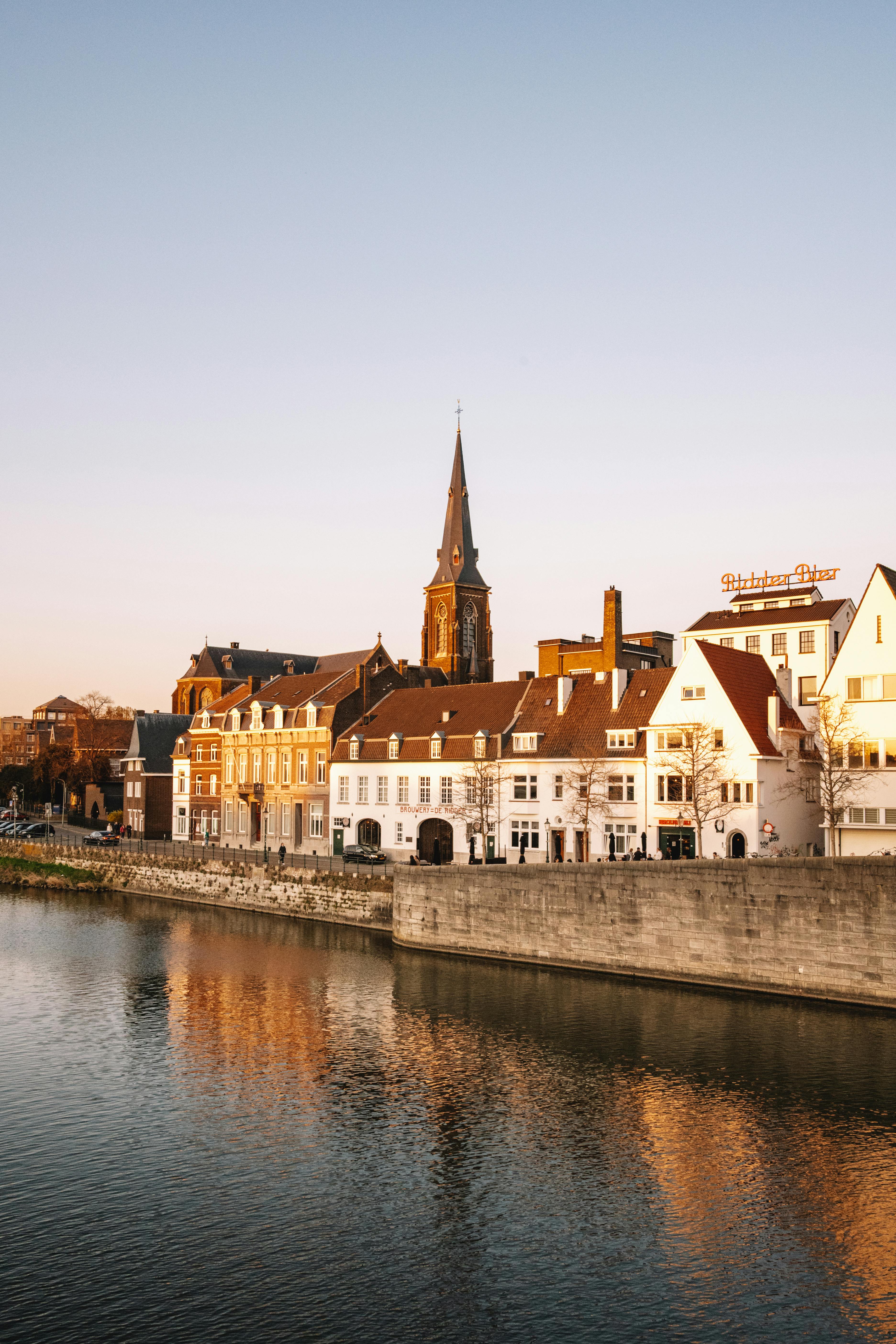 Picturesque view of Maastricht's historic buildings along the river at sunset, Limburg, Netherlands.