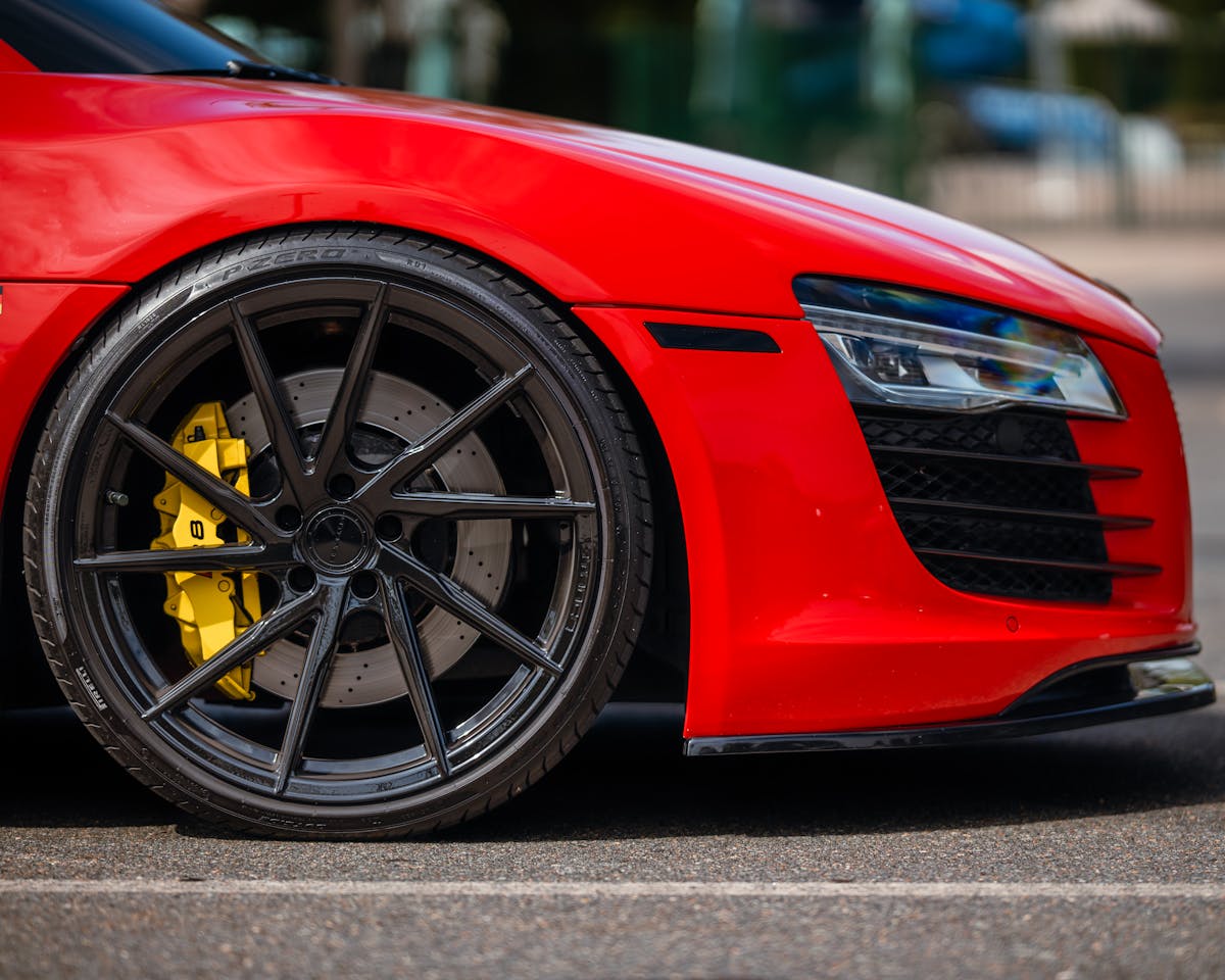 Primo piano di un'auto sportiva di lusso con vernice rossa metallizzata