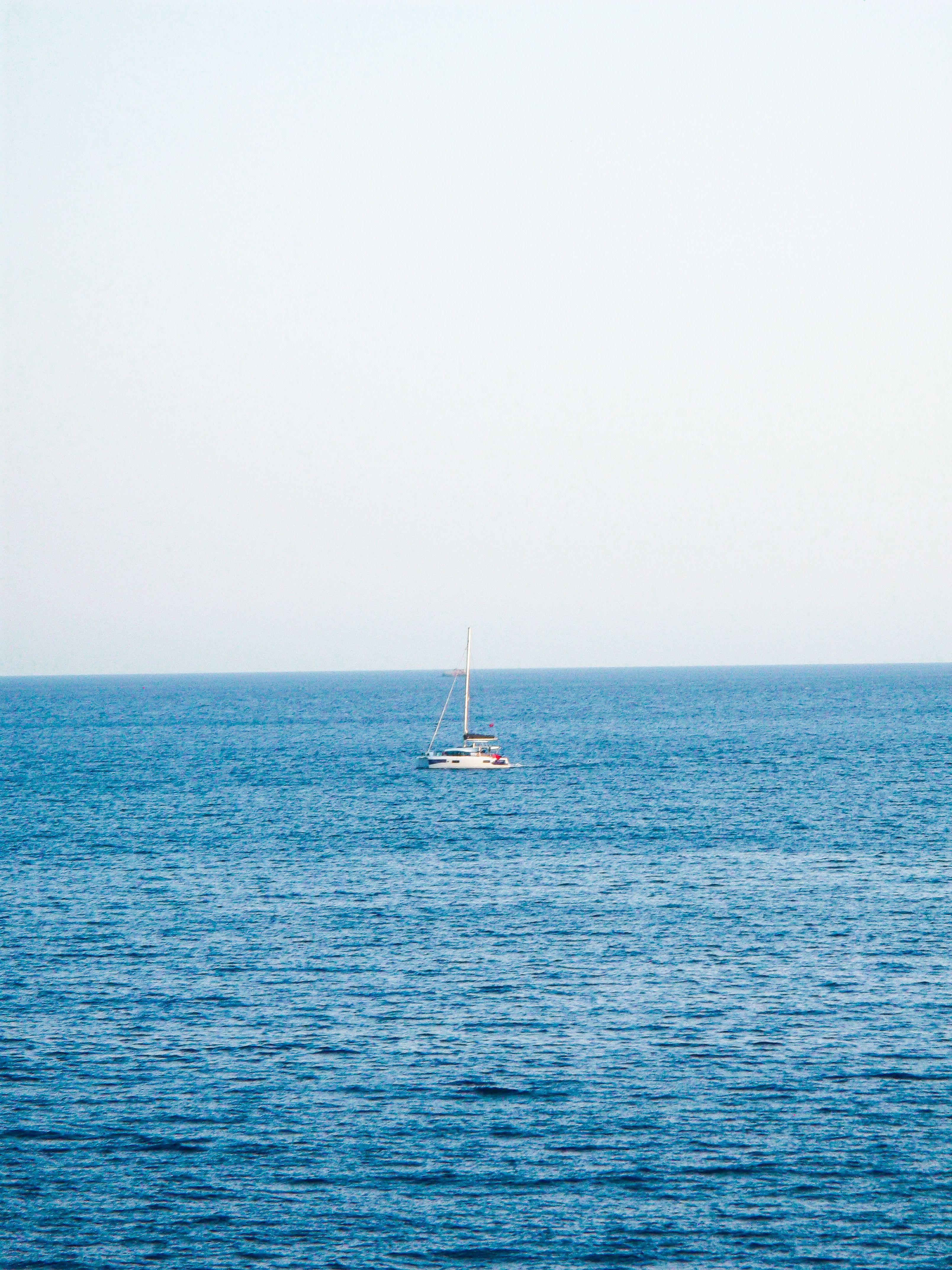 Sailboat on Calm Blue Ocean Under Clear Sky · Free Stock Photo