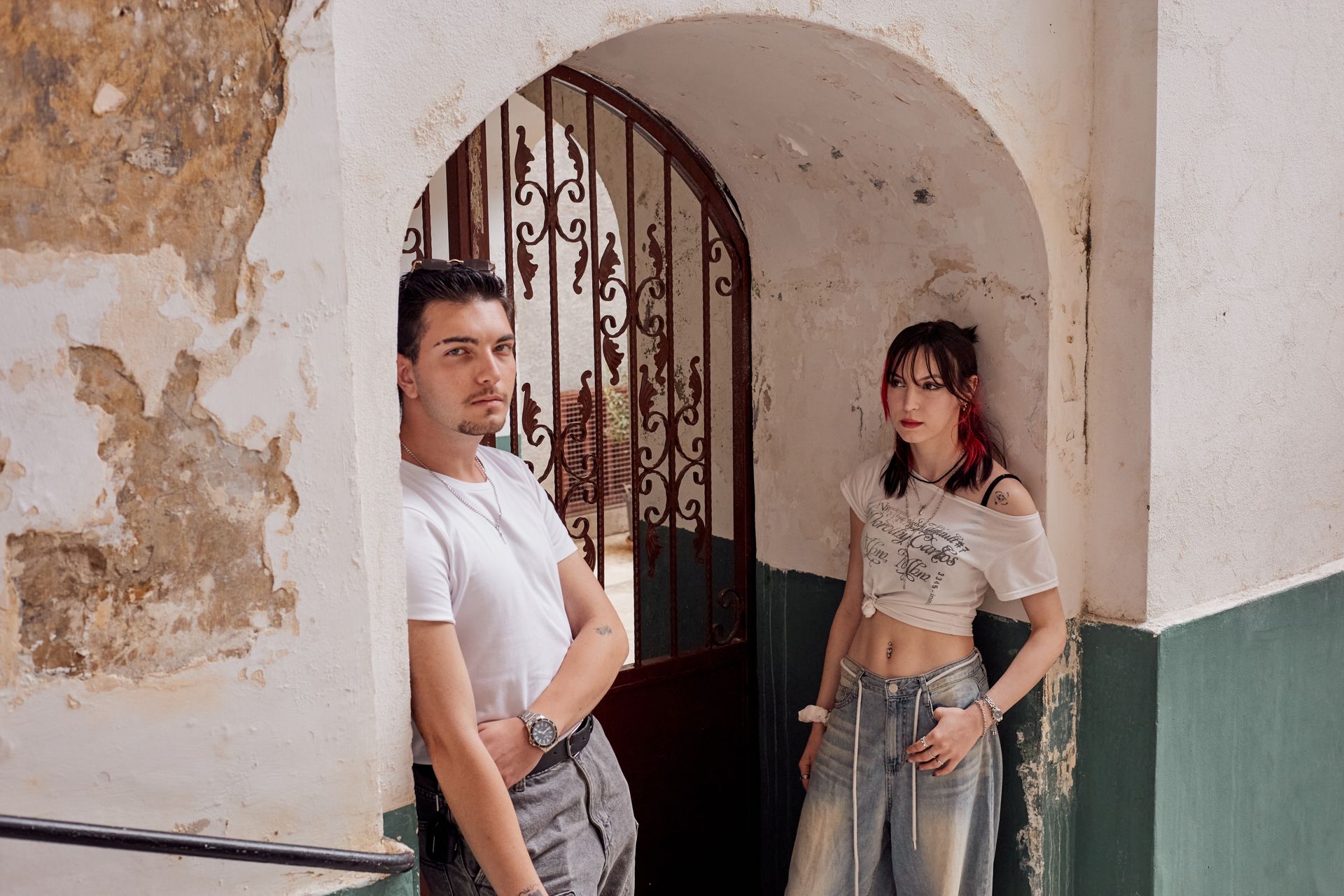 Stylish young couple posing by an archway in Istanbul, showcasing fashion and urban charm.
