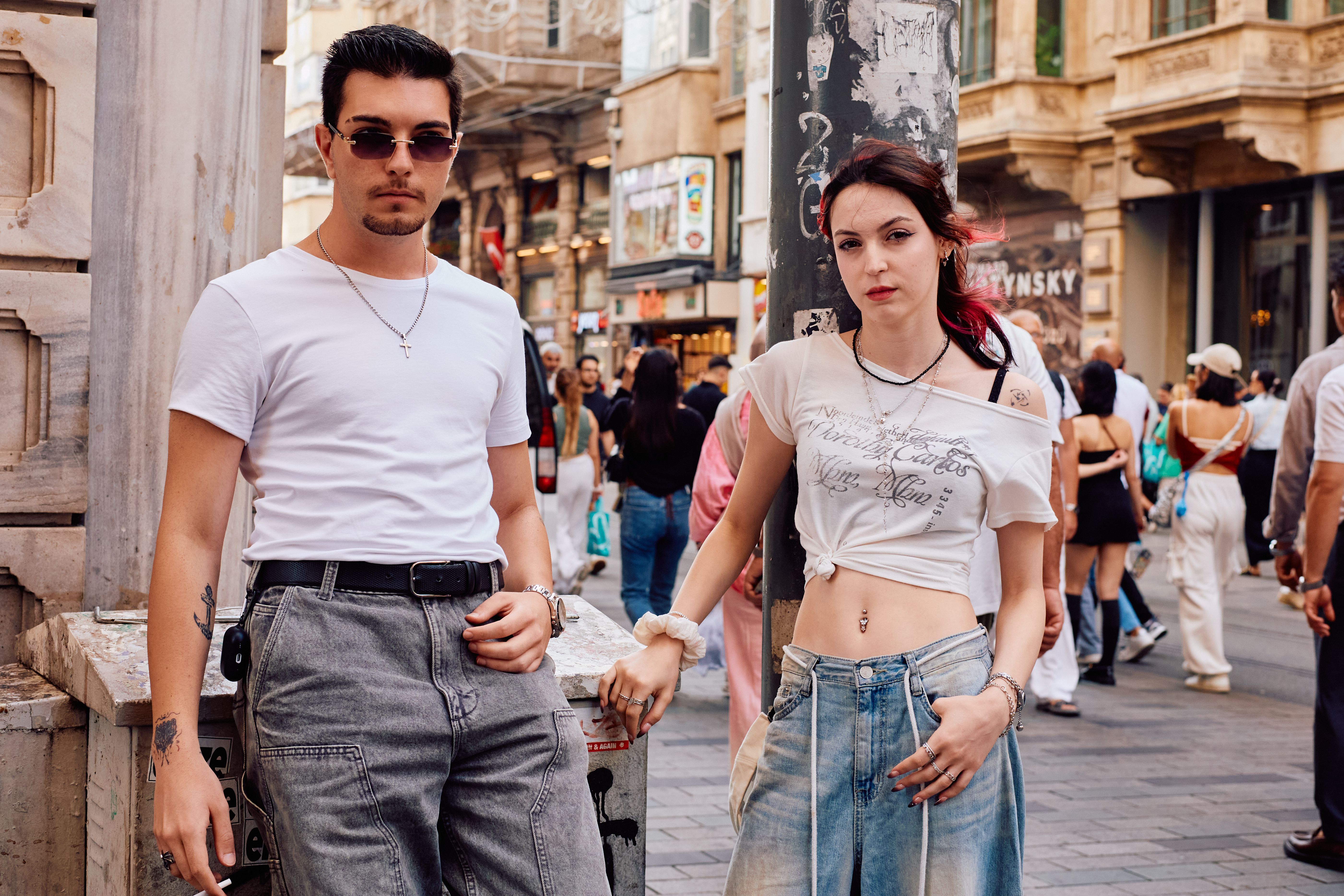 A stylish person wearing a 90s band t-shirt and high-waisted vintage jeans walking down a city street
