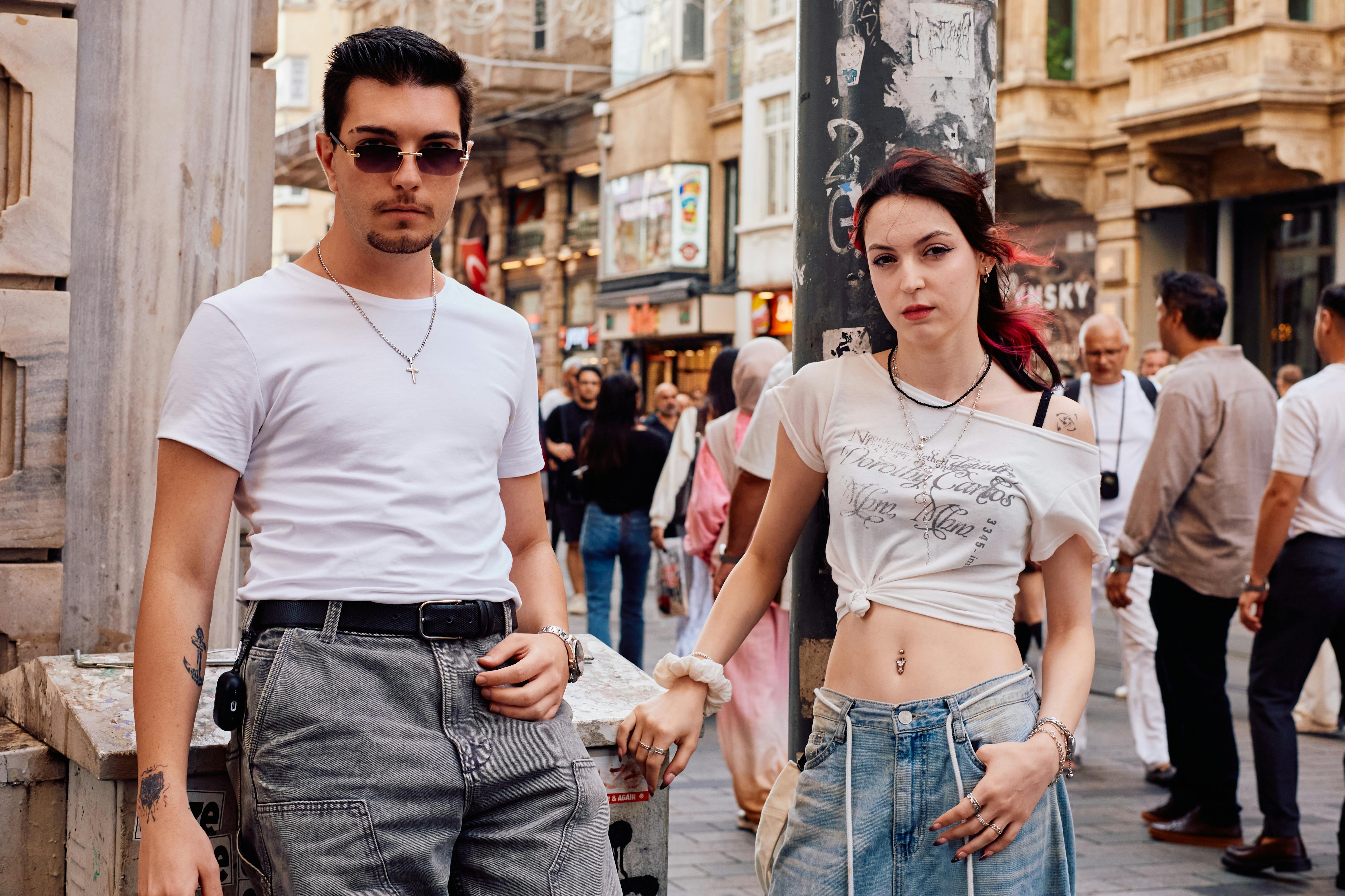 Young adults pose stylishly on a bustling street in Istanbul, highlighting casual urban fashion.