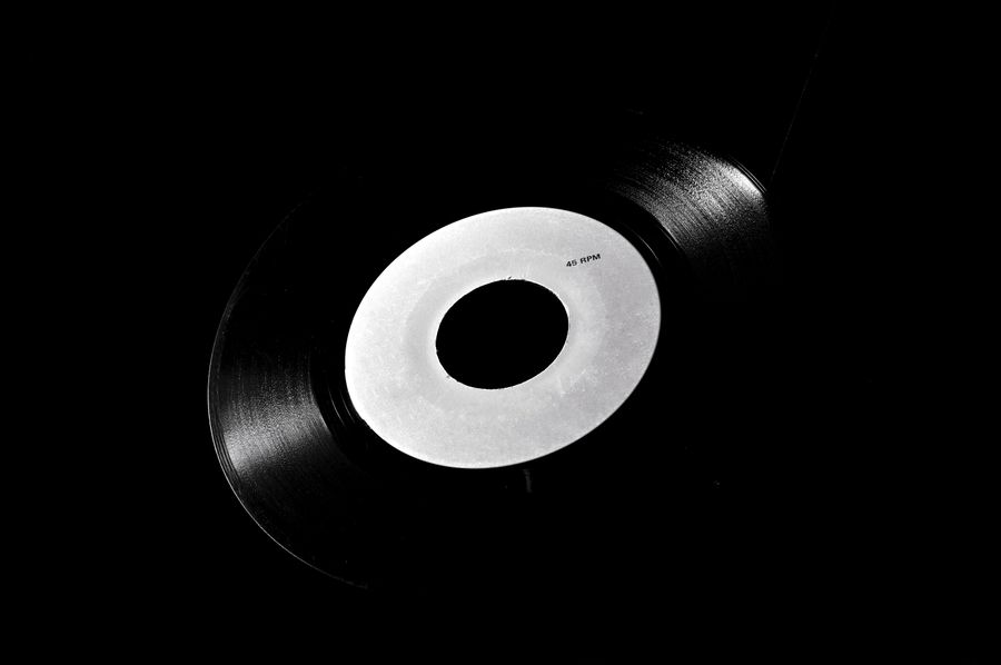 Gros plan sur le sillon d'un vinyle noir — la matière brute de la mémoire sonore
