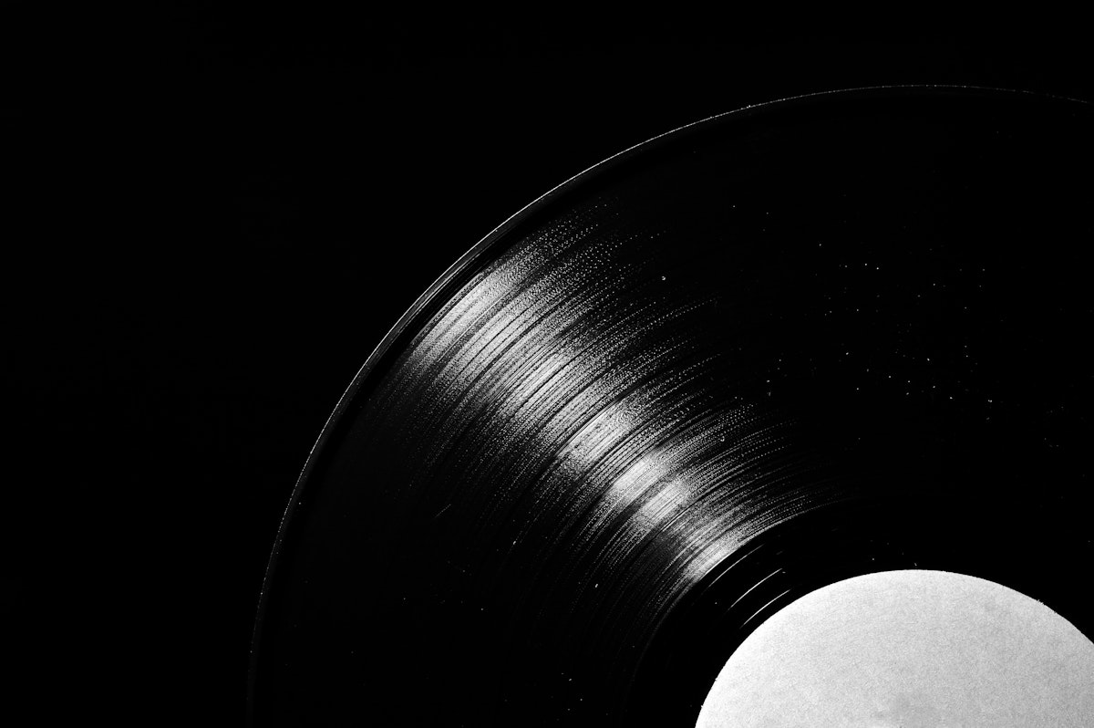 Close-up of vinyl record grooves against a dark background