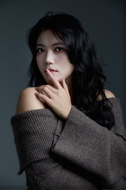 Free Elegant portrait of a woman with dark hair in a cozy sweater indoors. Stock Photo