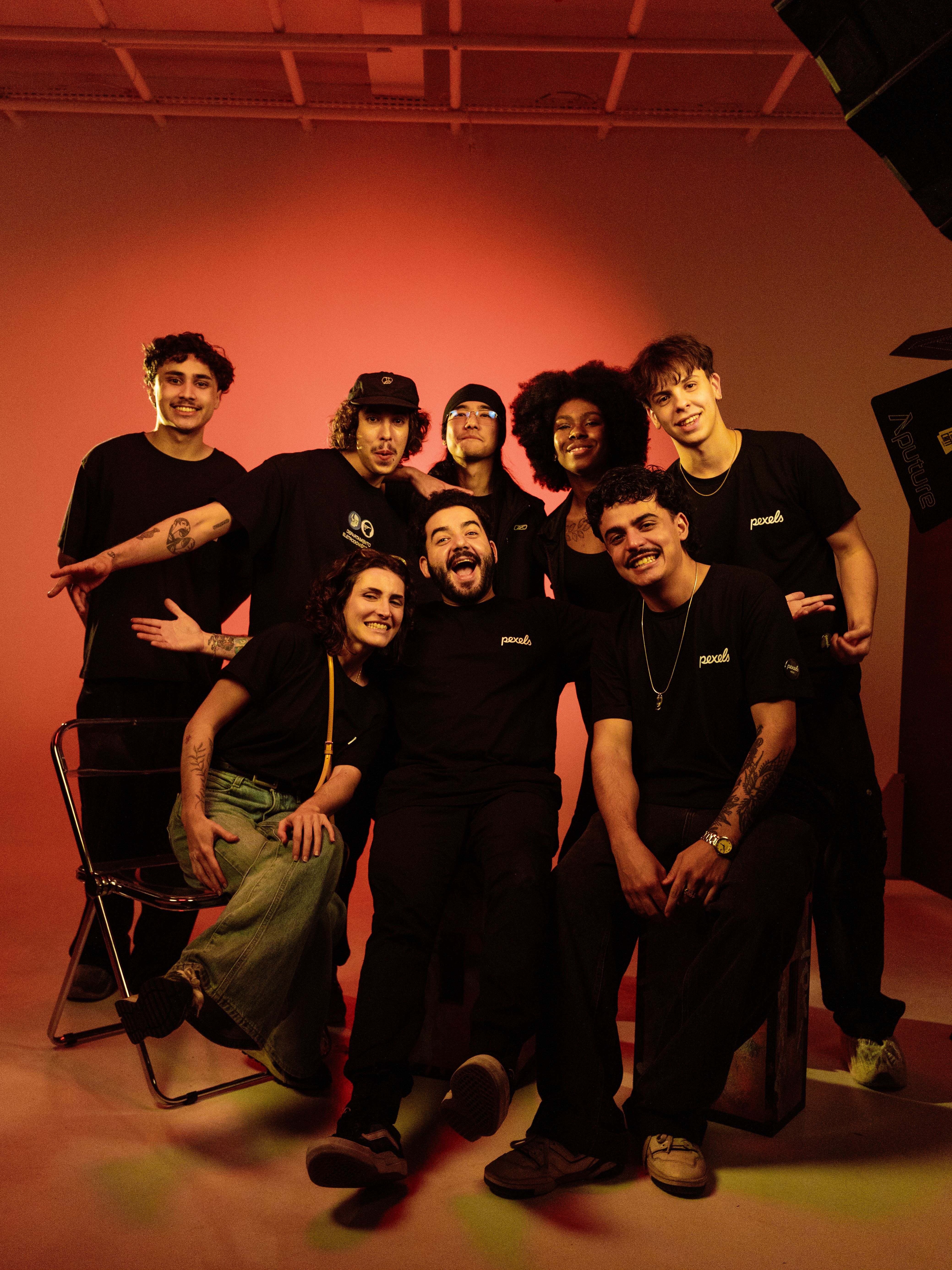 Diverse group of young adults posing for a vibrant studio portrait, exuding camaraderie and happiness.