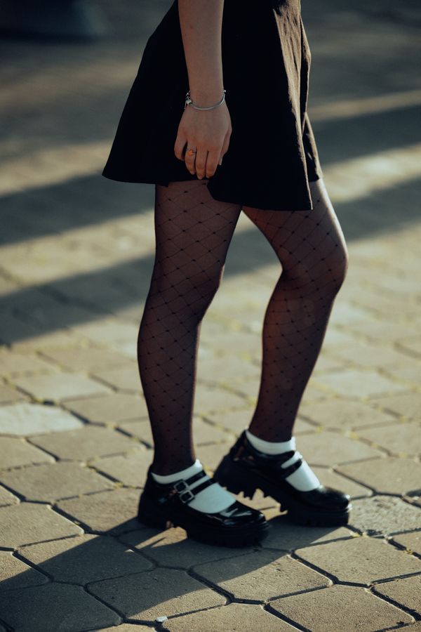 woman wearing pleated skirt tights and loafers office
