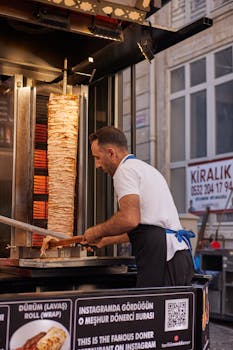 A street vendor in Istanbul skillfully prepares a traditional Turkish döner kebap outdoors.