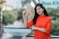 Young Woman in Traditional Dress with Fan Outdoors