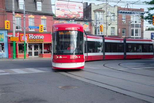 A streetcar traverses downtown Toronto near Parliament Street, showcasing urban transit.