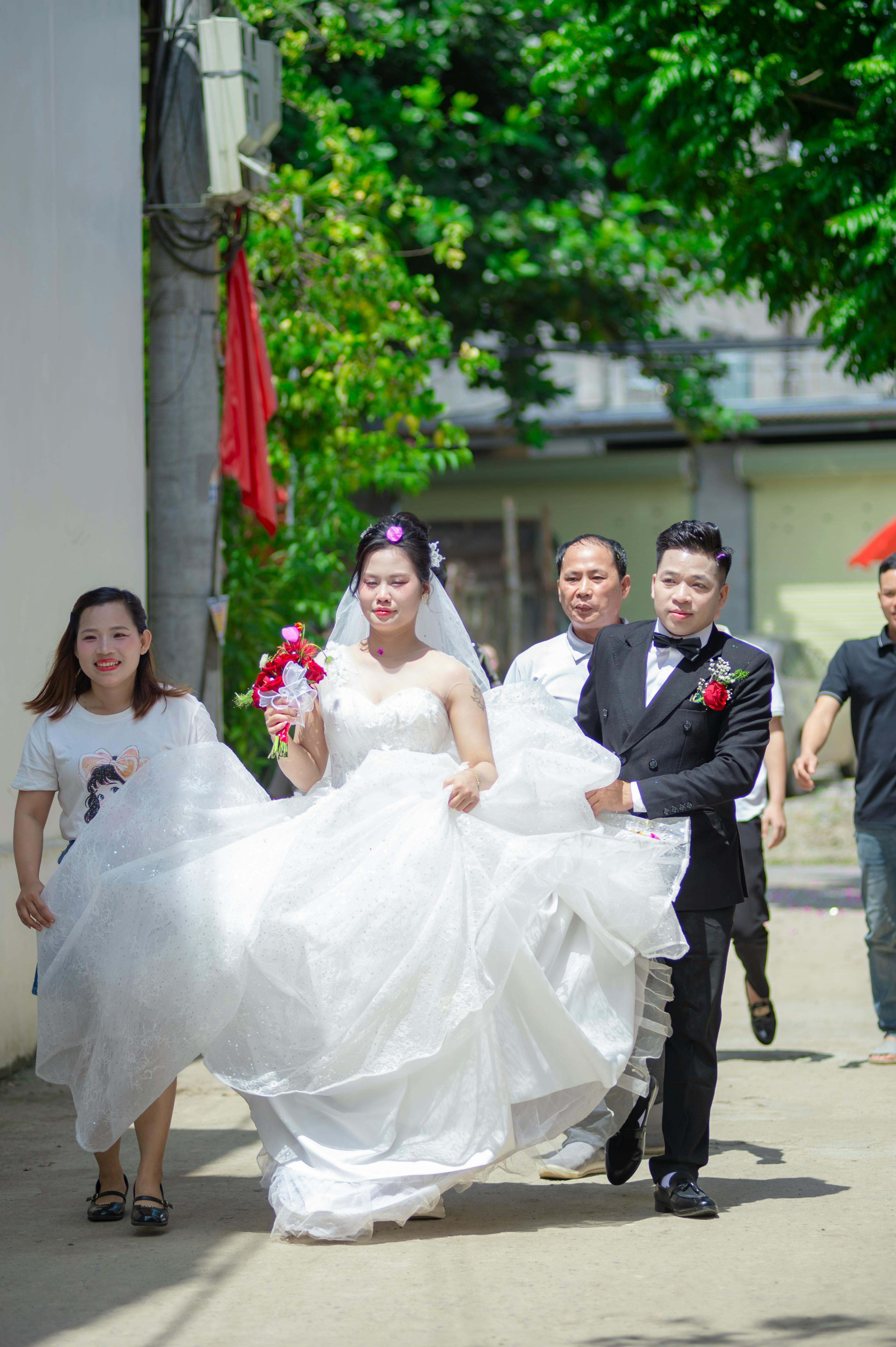 Ücretsiz Gelin ve damadın resmi kıyafetler giydiği neşeli bir açık hava Vietnam düğünü. Stok Fotoğraflar