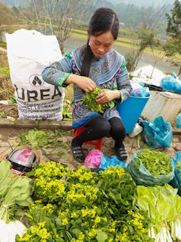 Woman in traditional attire at a vibrant vegetable market in Lào Cai, Vietnam.
