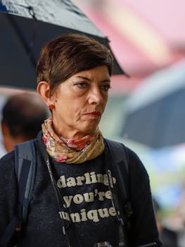 A thoughtful woman holding an umbrella at a market in Lào Cai, Vietnam.