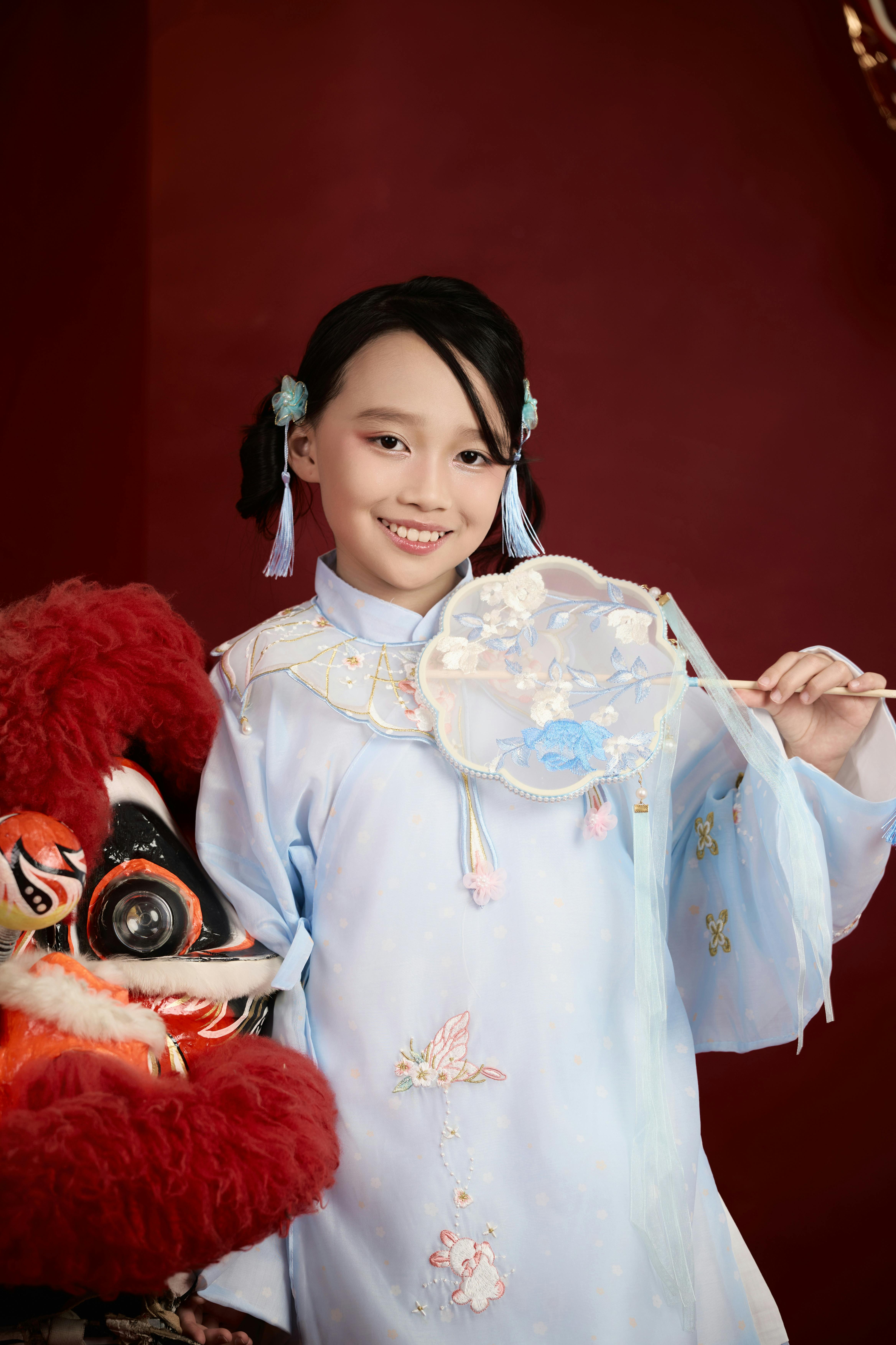 免费 身着传统服饰、手持舞狮面具的越南女孩肖像，展现文化优雅。 素材图片