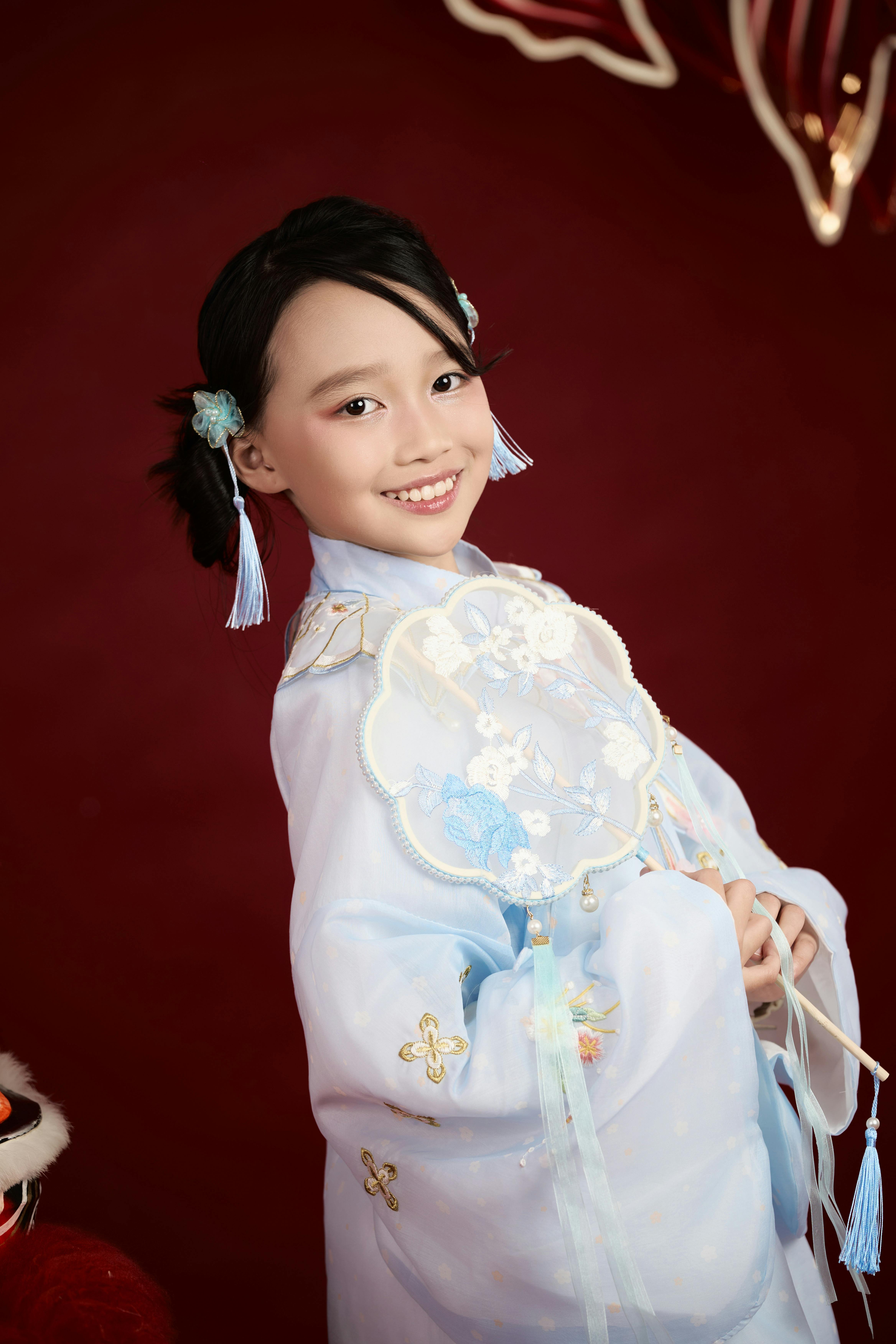 免费 身着传统服装的年轻女孩在工作室中微笑。 素材图片