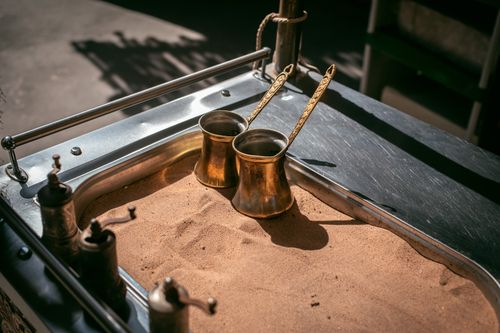 Free Close-up of cezves in sand for Arabic coffee in Dubai market. Stock Photo