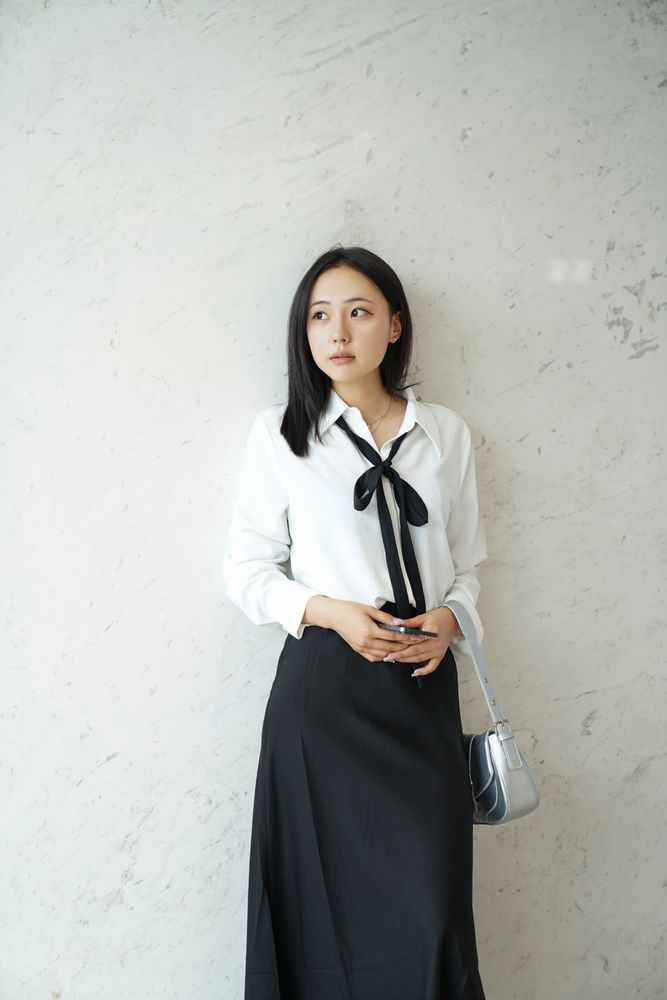 Woman in a chiffon blouse and A-line skirt