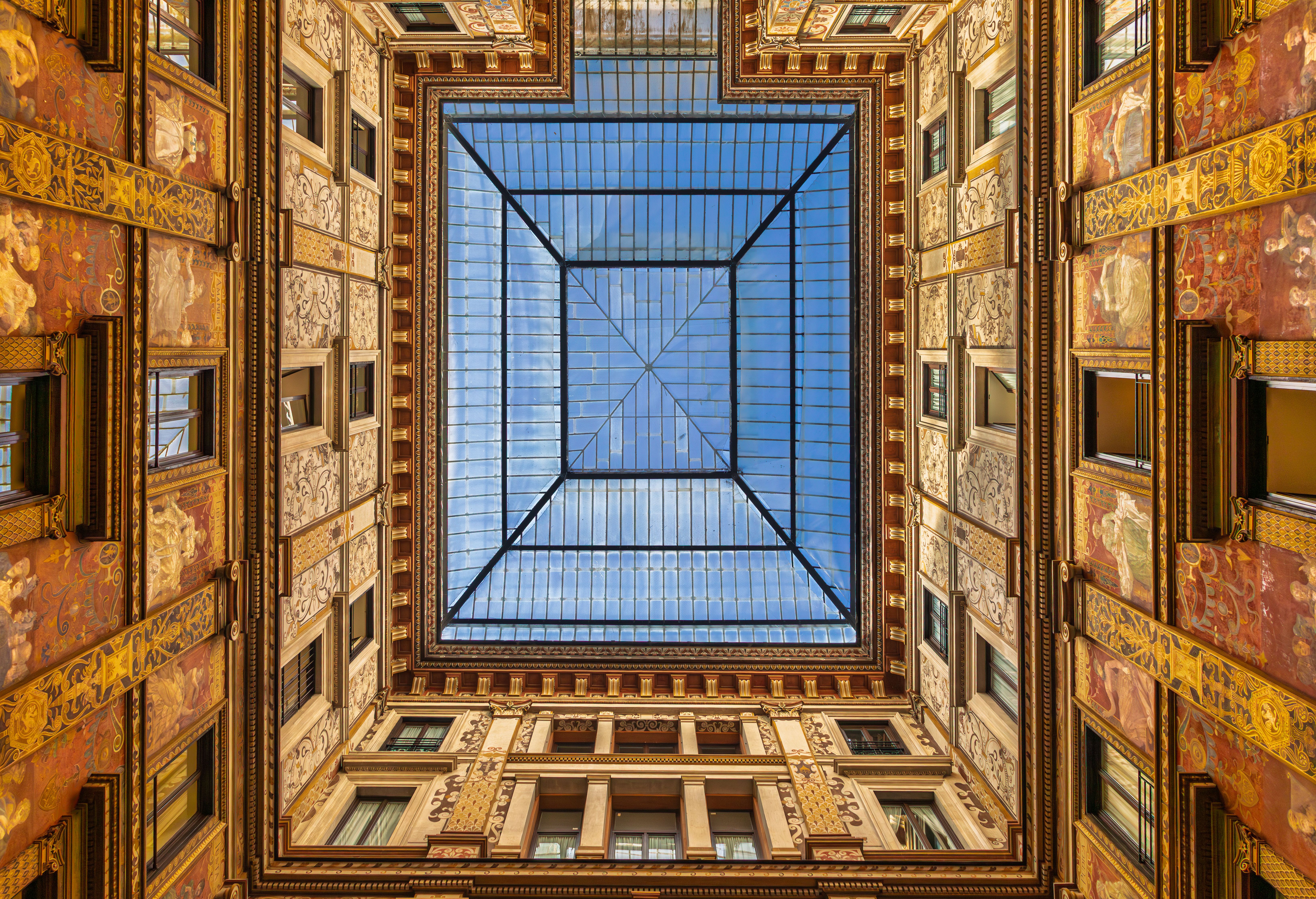 Looking up at the beautiful glass ceiling of Sciarra Gallery in Rome showcasing ornate architecture.
