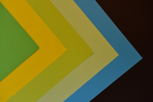 Free Abstract composition of colorful papers in geometric layout on dark background. Stock Photo