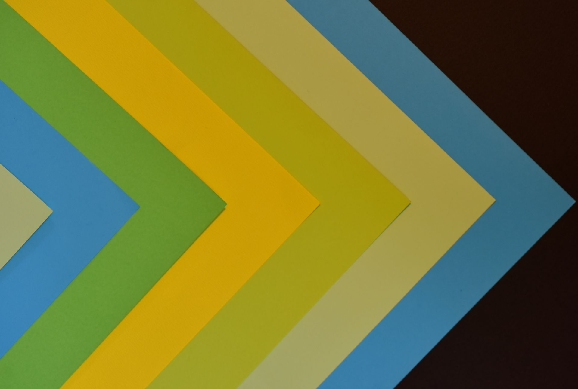 Vibrant abstract design featuring a colorful chevron pattern with layered paper textures.