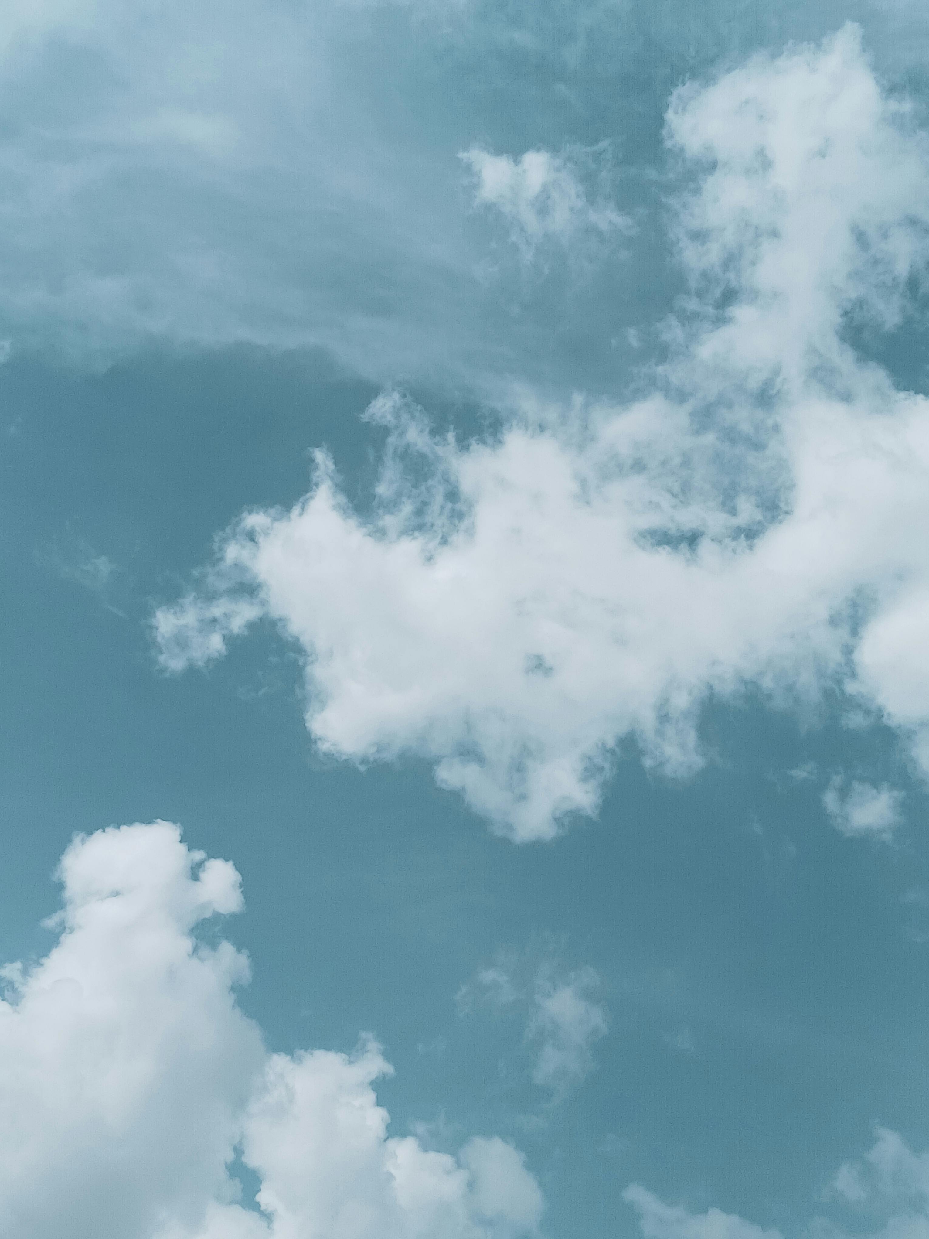 grátis Uma cena tranquila de nuvens brancas e fofas contra um céu azul suave, perfeita como plano de fundo. Foto profissional