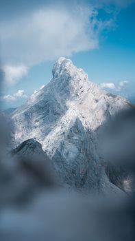 A majestic mountain peak stands tall under a clear blue sky, creating a breathtaking outdoor scene.
