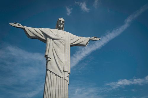 Free Stunning view of Cristo Redentor statue in Rio de Janeiro, Brazil, with arms wide open against a clear blue sky. Stock Photo