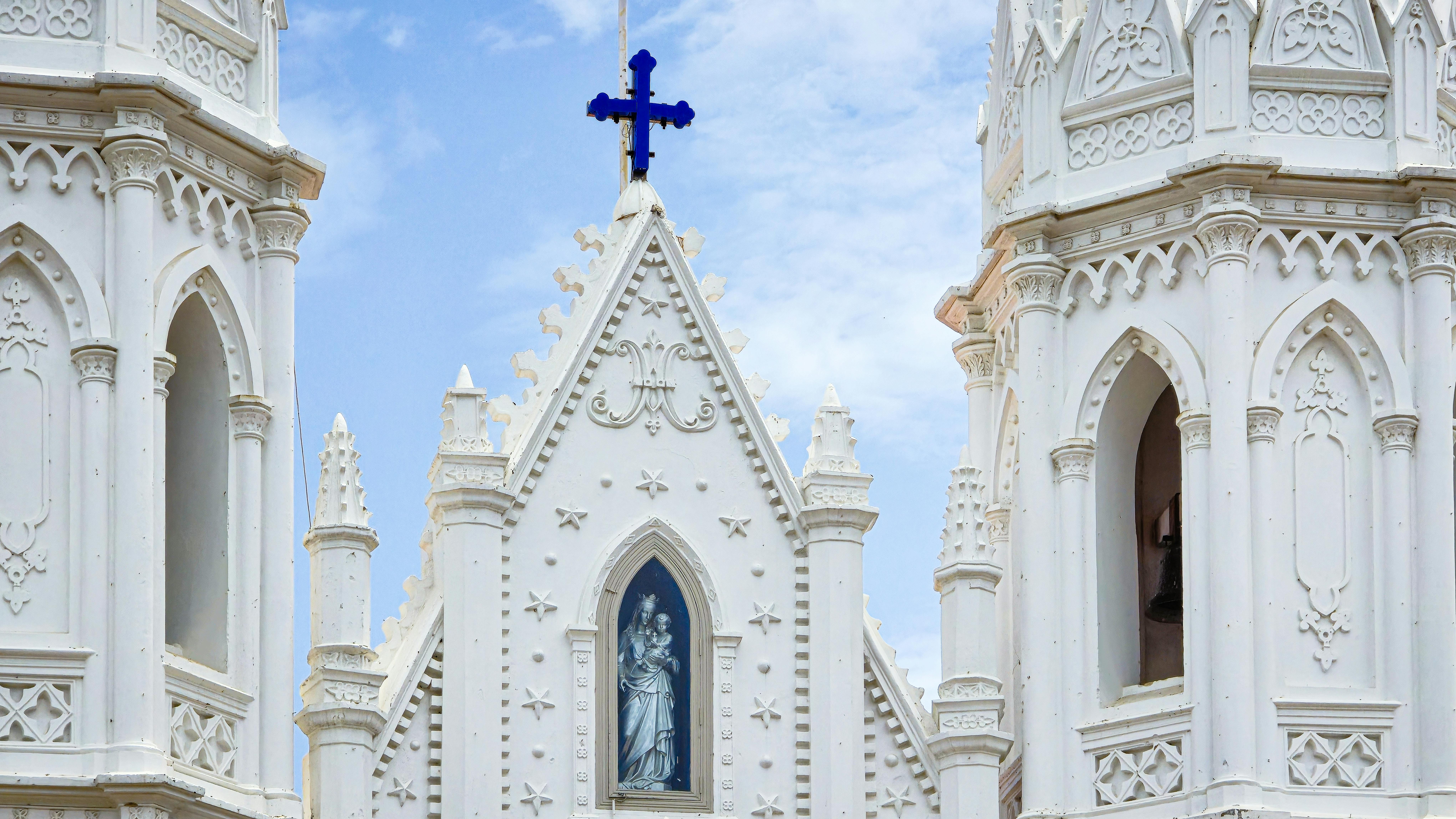 Stunning Gothic church facade in Velankanni, India with ornate details and clear blue sky.