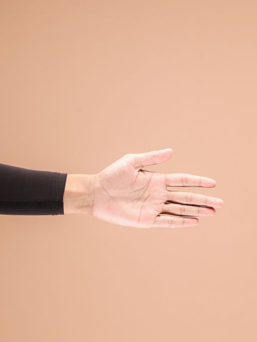 Free Close-up of an outstretched hand against a warm neutral backdrop, emphasizing simplicity and gesture. Stock Photo
