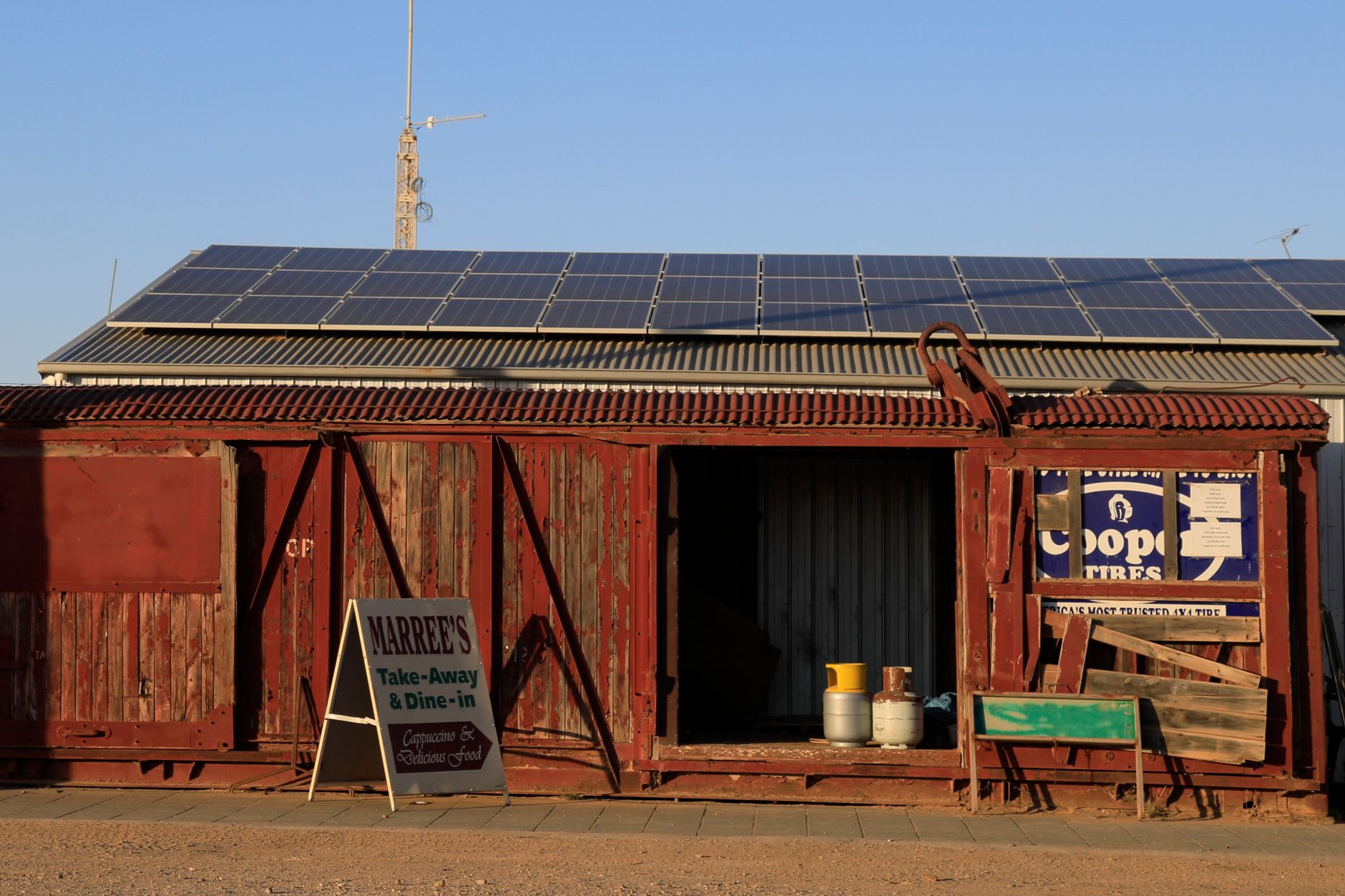 A weathered regional shopfront under late light, standing in for the small businesses that wear every outage in their till, fridge and payroll