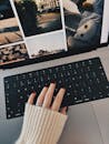 Close-up of a hand with painted nails on a laptop keyboard, cozy autumn vibe.