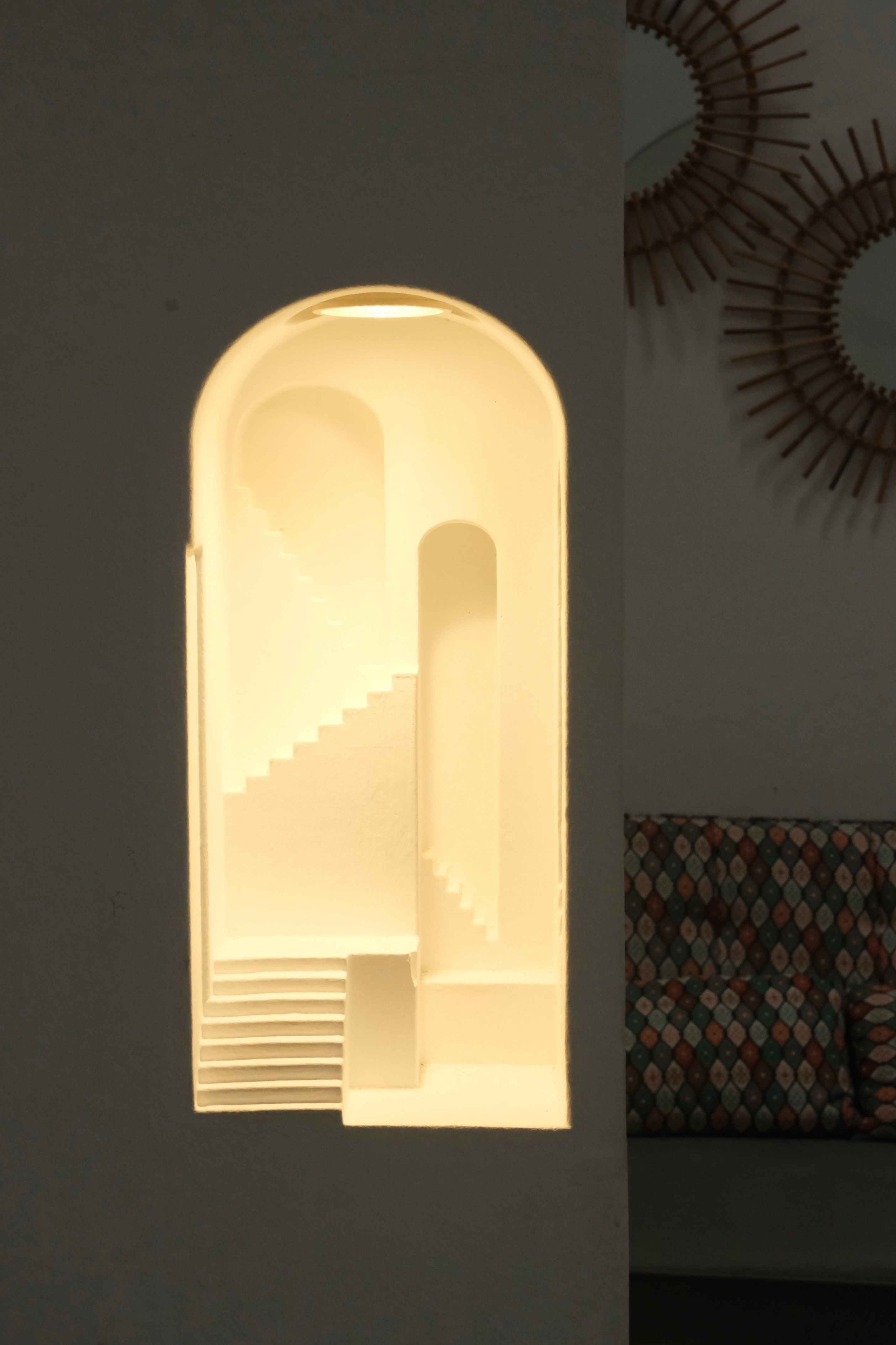 Illuminated modern staircase model with geometric patterns in a cozy setting.