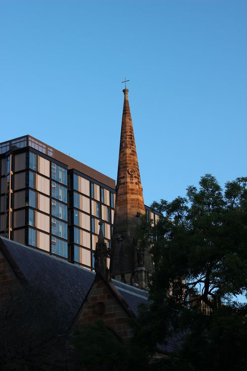 Free Church spire in Sydney with modern buildings at dusk, symbolizing tradition and progress. Stock Photo