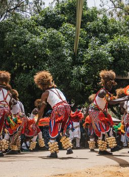Colorful African traditional dance performance outdoors under greenery.
