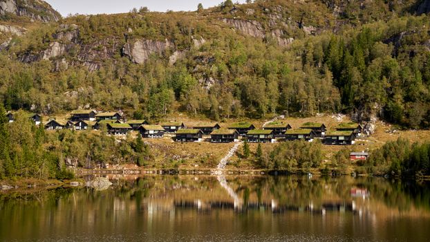 Discover the tranquil beauty of traditional Norwegian cabins surrounded by lush forests in Troms.