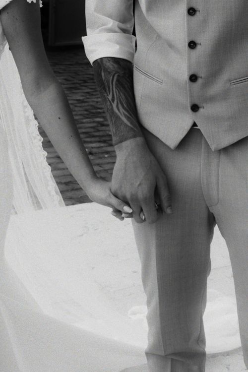 Free Close-up of a couple holding hands in wedding attire, black and white. Stock Photo
