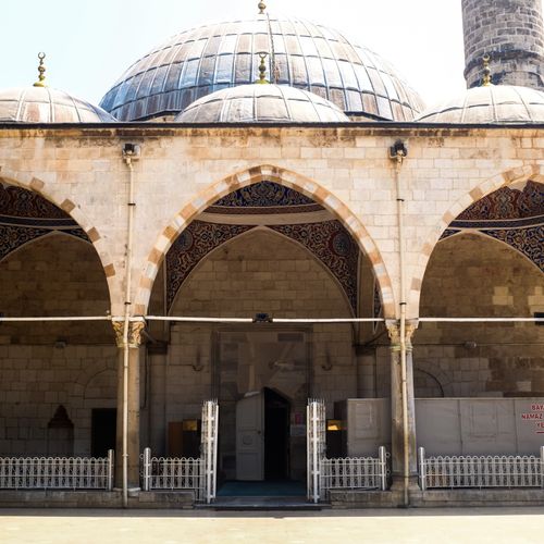 Free Front view of a historic mosque showcasing domes and arches under a sunny sky. Stock Photo