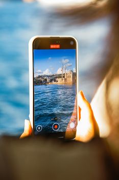 A smartphone captures a vivid image of Ortaköy Mosque by the Bosphorus.