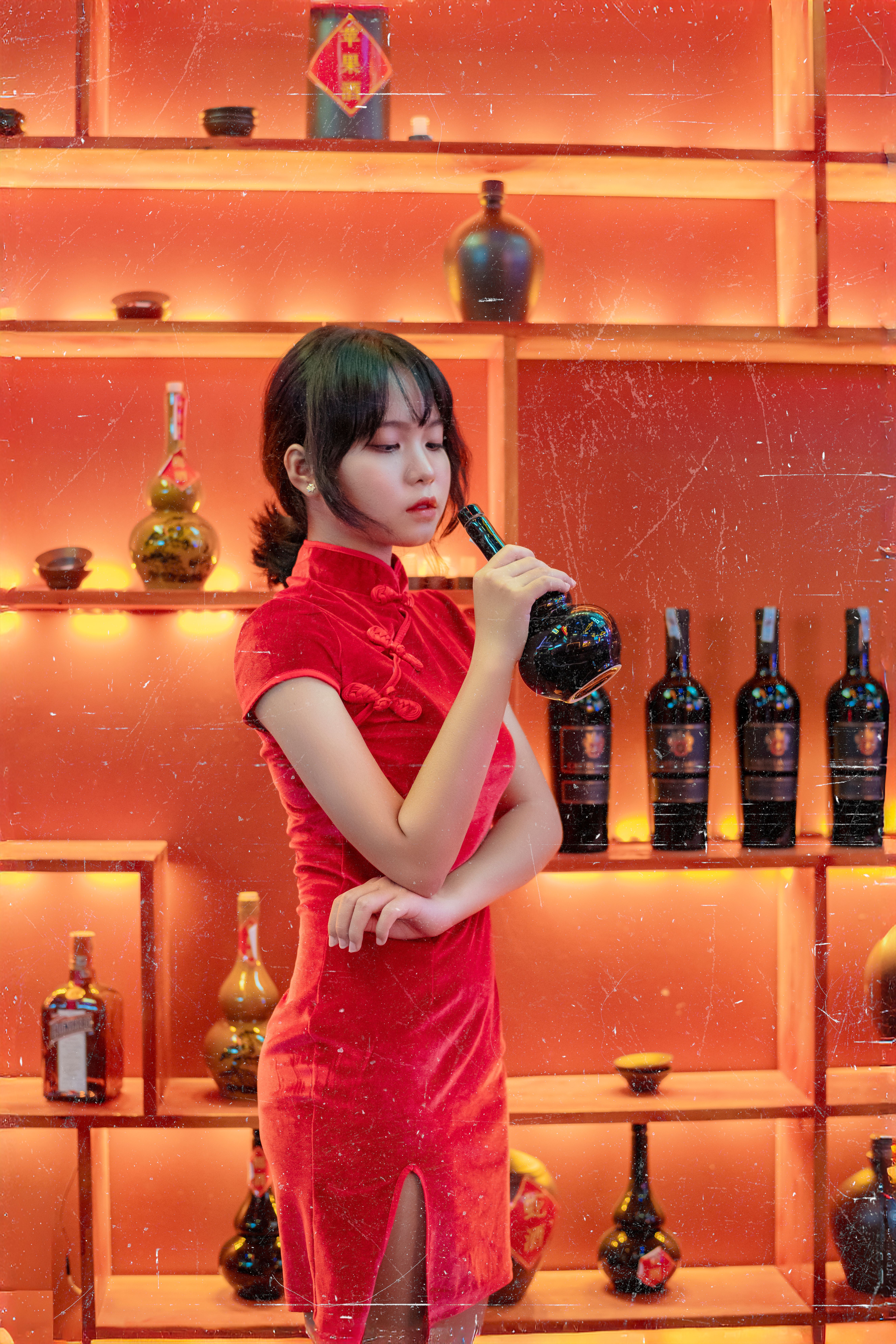 Asian Woman in Red Dress Holding a Bottle  Free Stock Photo