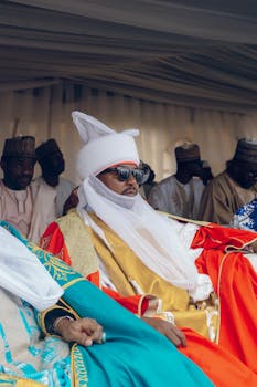 Man in traditional African regalia at a cultural ceremony, exuding elegance.
