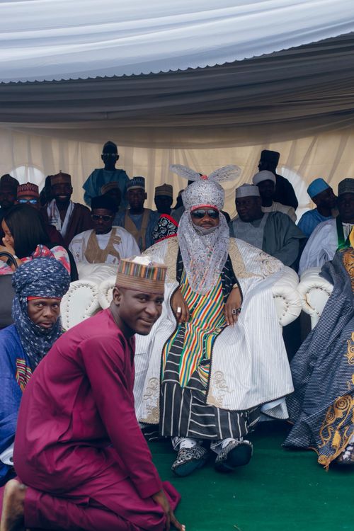 Free A Nigerian Emir in traditional attire presides over a cultural ceremony with a diverse group of attendees. Stock Photo