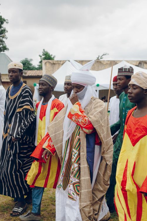 Free Men in traditional African attire participating in a cultural festival outdoors. Stock Photo