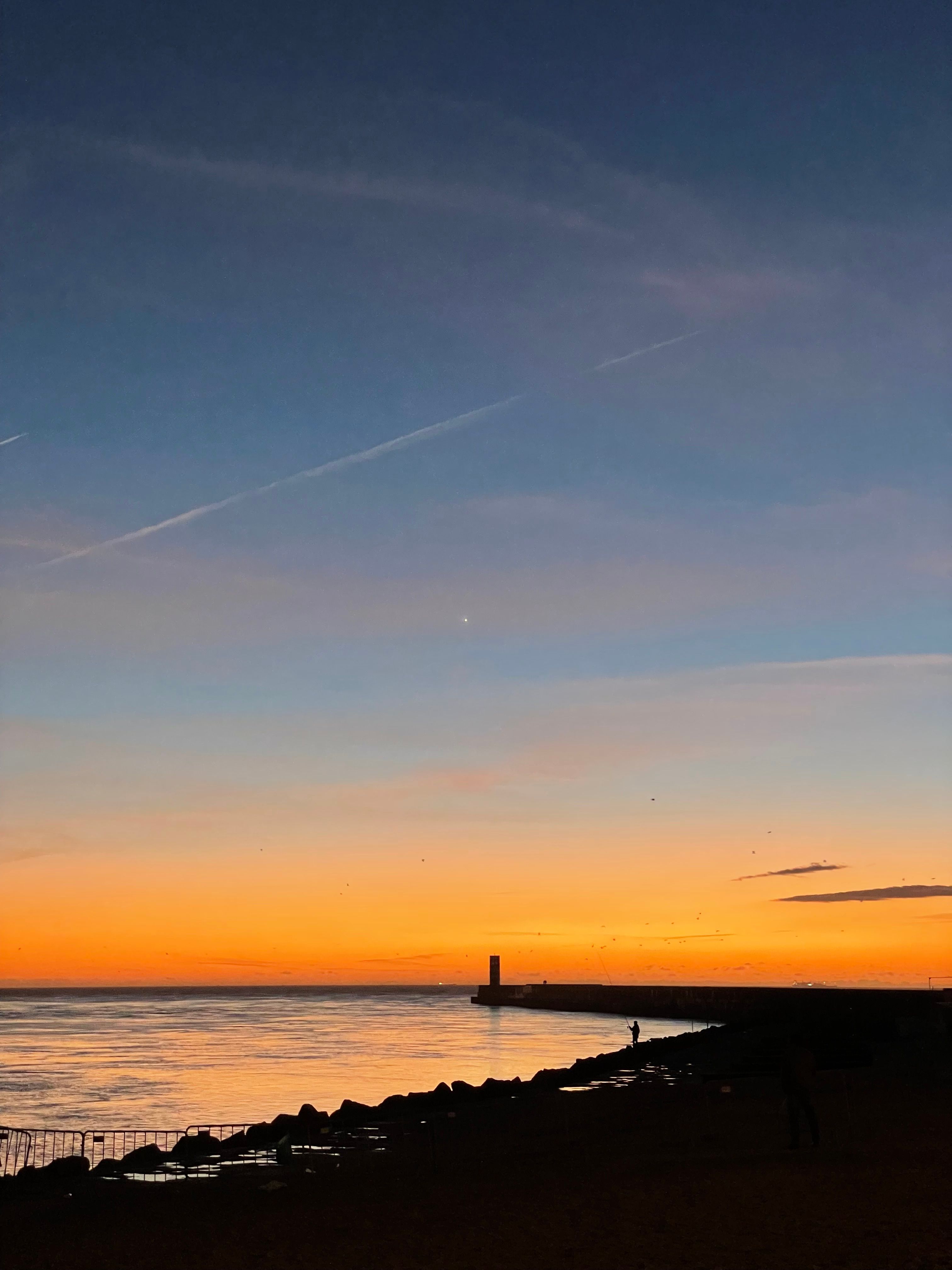 Vibrant sunset over the Atlantic Ocean in Porto, Portugal, capturing a serene seascape.