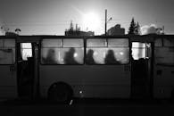 这是一张叶卡捷琳堡巴士内的黑白风景照片，乘客的轮廓在明媚阳光下清晰可见