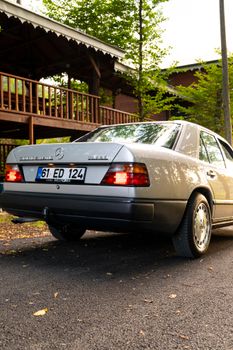 Vintage Mercedes-Benz sedan in outdoor setting with wooden pavilion background.