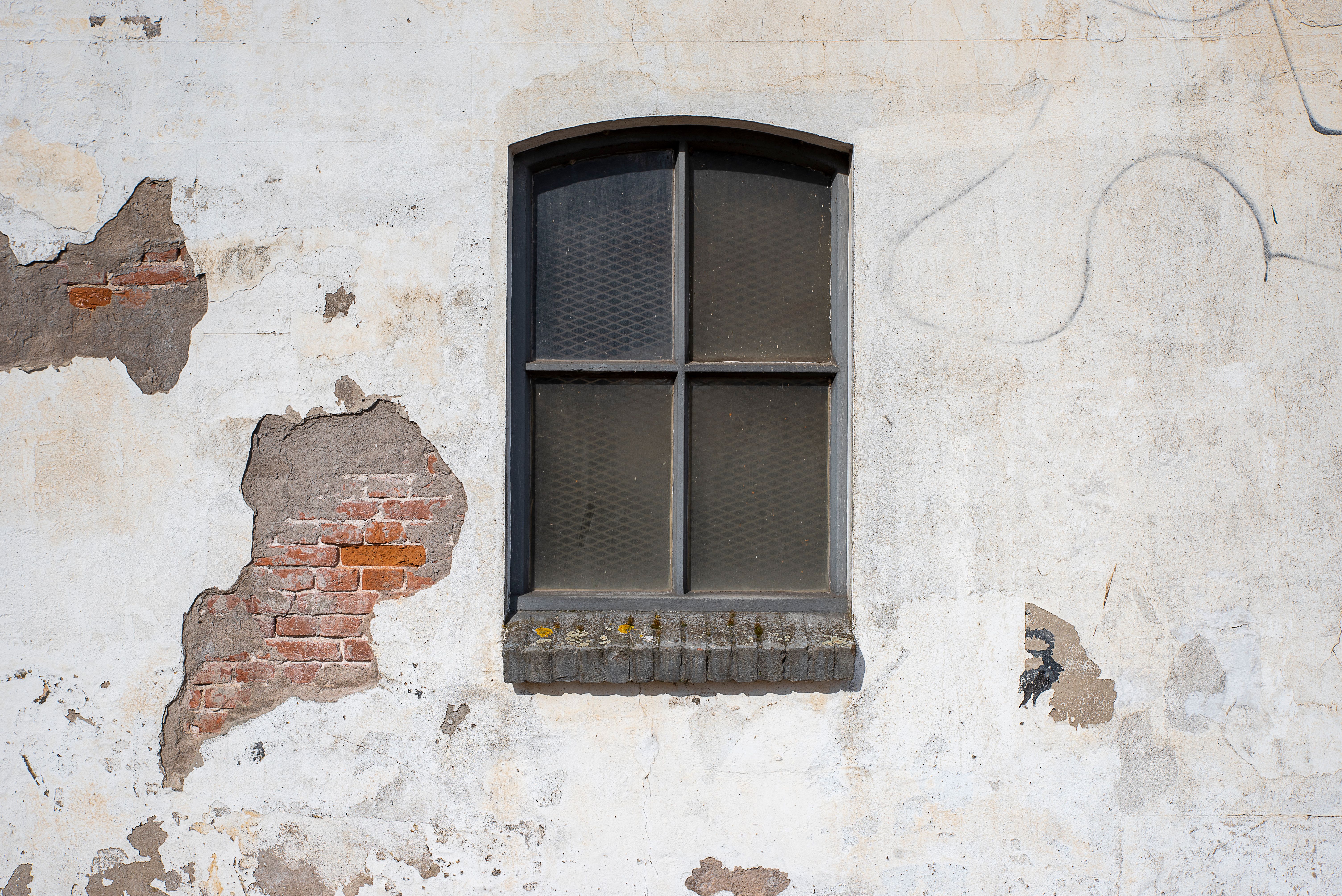 Cracked commercial building exterior with visible foundation damage highlighting urgent foundation repair needs in Houst